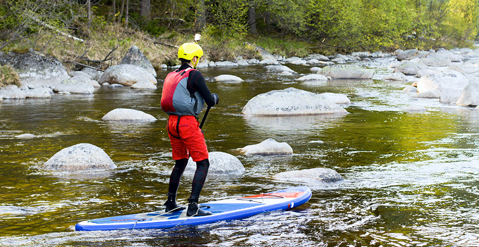 Person paddle-boarding on a river