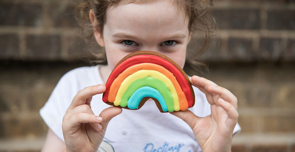 Girl with a rainbow decorated cookie